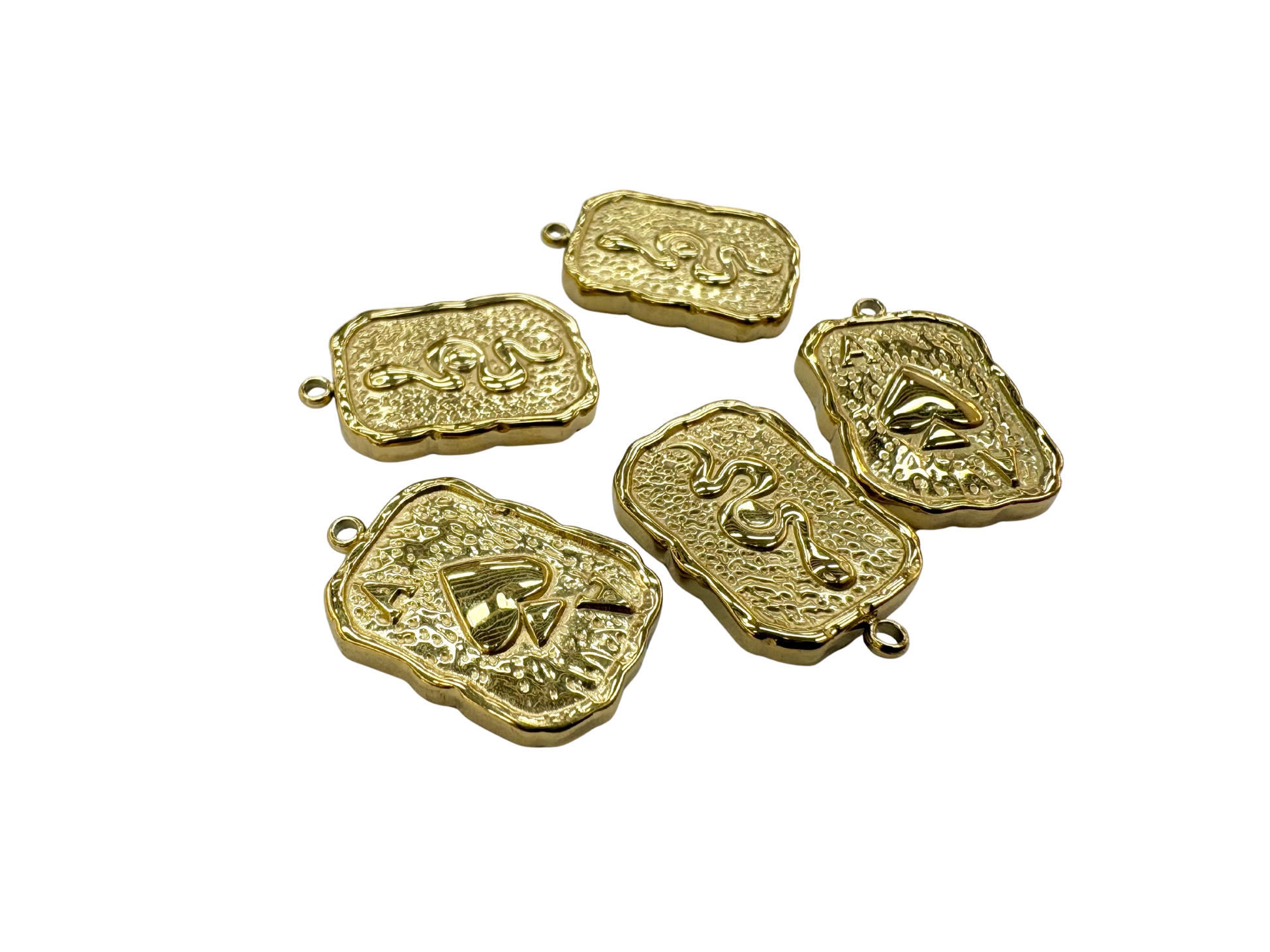 Five gold ace of spades pendants with embossed designs on a white background