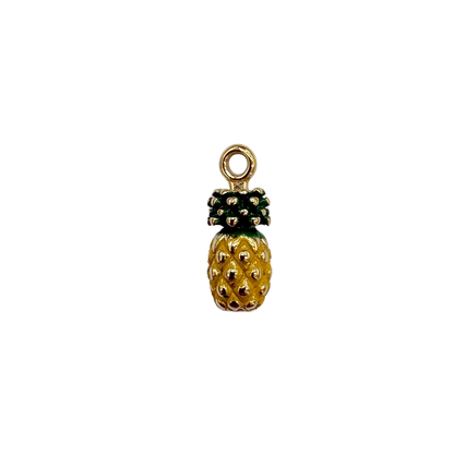 A small pineapple-shaped charm with a gold-tone body, textured yellow and green enamel details, and a top loop, centered on a plain white background.